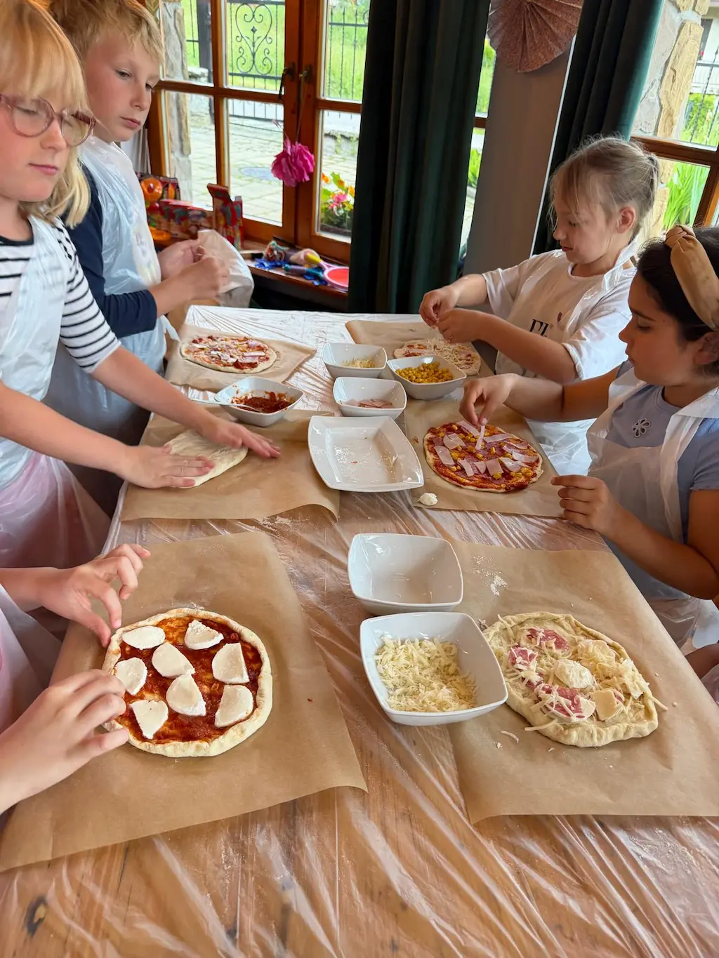 Dzieci jedzą własnoręcznie przygotowaną pizzę podczas warsztatów Górskiej Akademii w Zakopanem