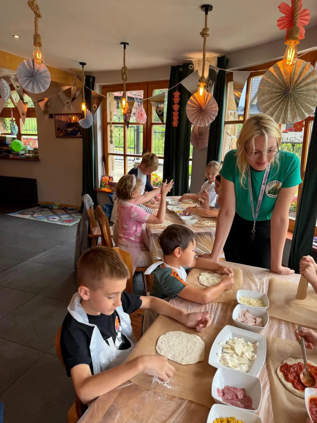 Dzieci przygotowują ciasto na pizzę podczas warsztatów Górskiej Akademii w Zakopanem